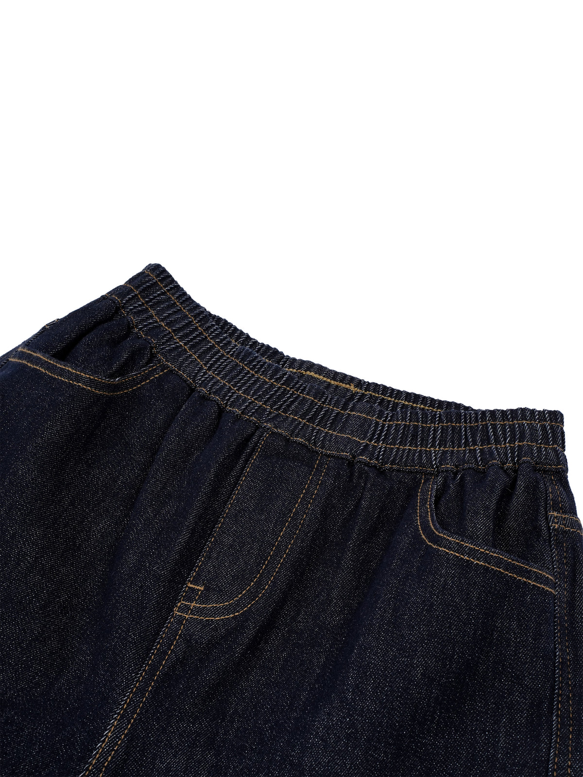 Close-up of dark indigo denim pants showing the elastic waistband, front pocket, and contrast stitching against a white background.