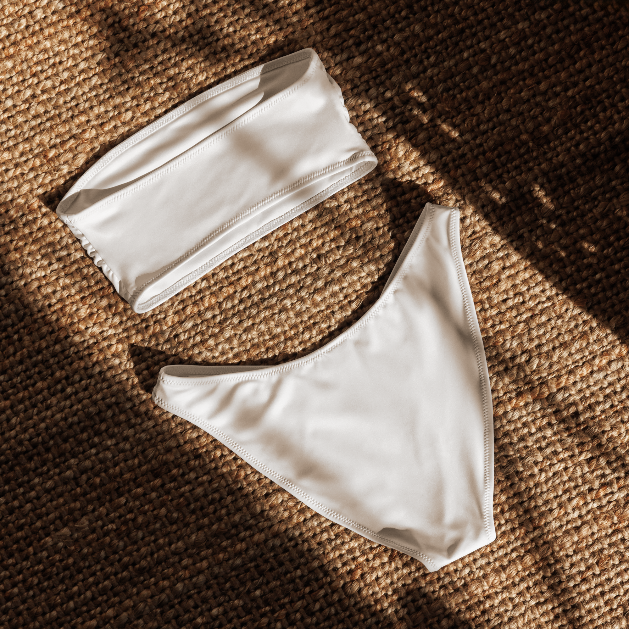 White bandeau top and high-waist bottom set on a textured brown surface