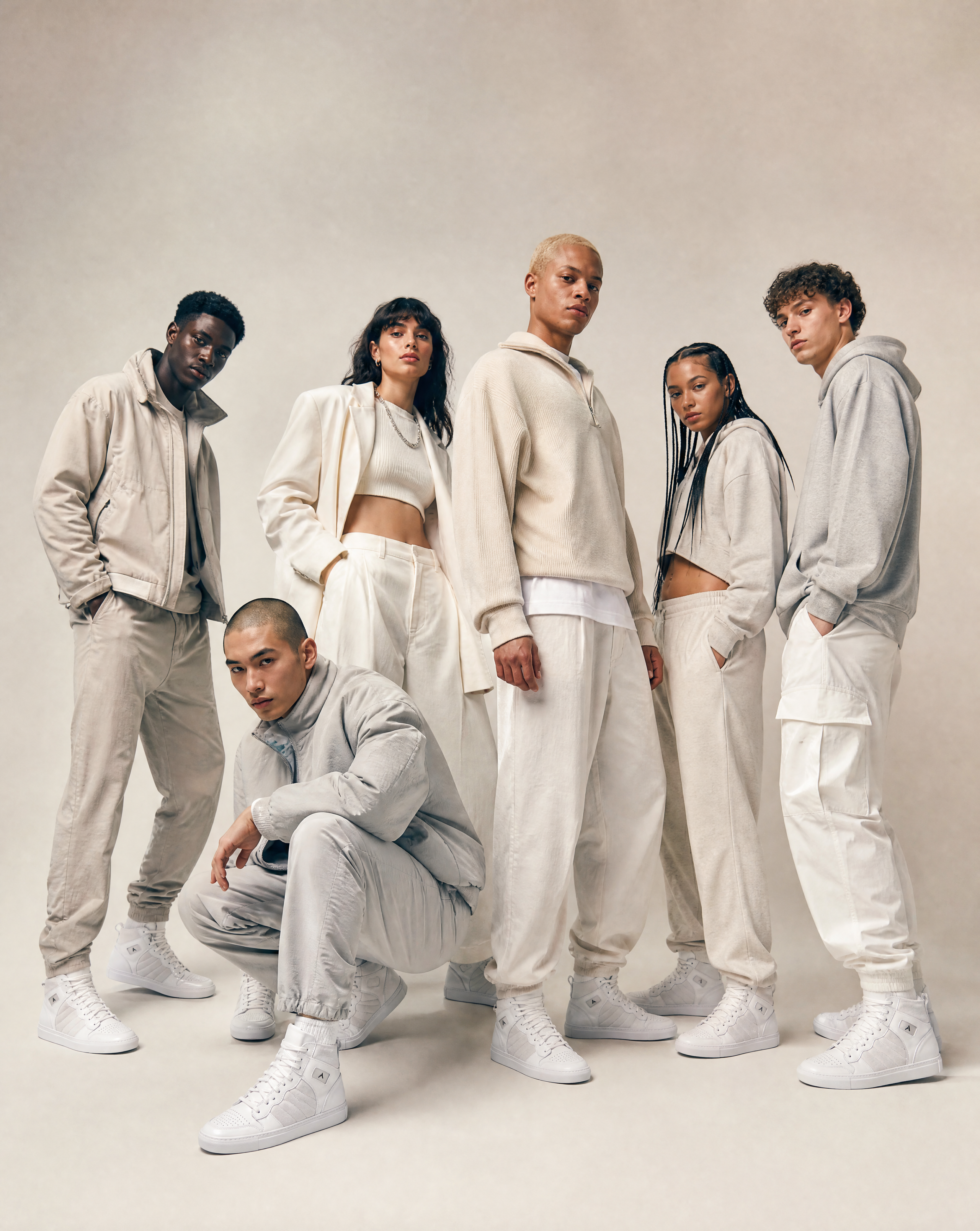 A group of six people wearing coordinated outfits with Arborstep signature sneakers in the white studio